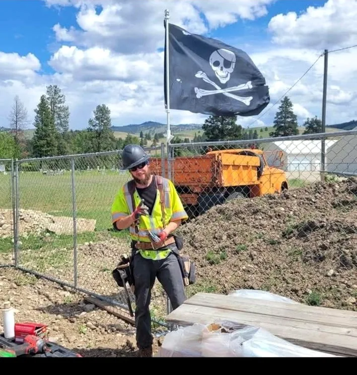 Brady Chismar on a jobsite beneath a Jolly Roger flag
